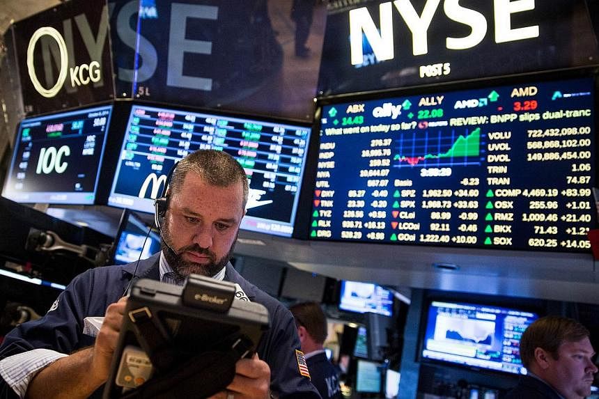 US stock markets cheered after the US central bank said in the minutes of its latest policy-seting meeting that it wants to keep interest rates close to zero for longer than expected, posting their biggest one-day gains in 2014. -- PHOTO: AFP&nbsp;