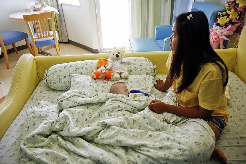 Gammy, a baby born with Down's Syndrome, is fed by his surrogate mother Pattaramon Janbua at a hospital in Chonburi province on Aug 3, 2014. -- PHOTO: REUTERS