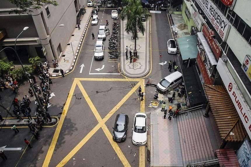 Police work at the scene of a grenade attack outside a shopping centre at Bukit Bintang in Kuala Lumpur on Oct 9, 2014. -- PHOTO: REUTERS
