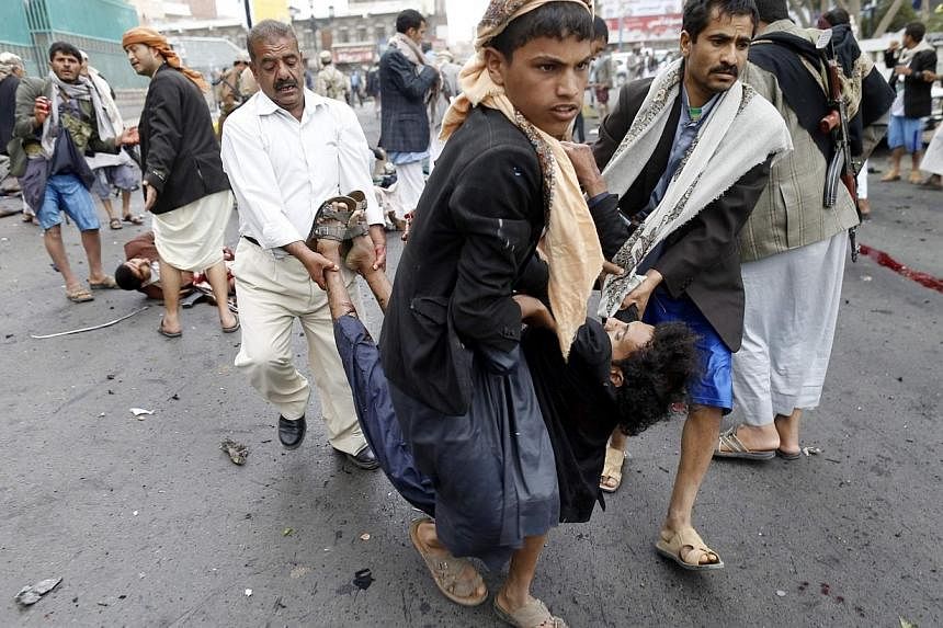 Shi'ite Huthi rebels carry a wounded man at the scene of a suicide attack in Sanaa on Oct 9, 2014.&nbsp;A powerful suicide bombing in the Yemeni capital has killed at least 43 people in an attack on supporters of Shi'ite insurgents who have overrun t