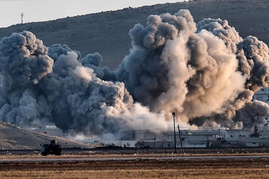 Smoke rises during airstrikes on the Syrian town of Ain al-Arab, known as Kobane by the Kurds, seen from the Turkish-Syrian border in the southeastern village of Mursitpinar, Sanliurfa province, on Oct 8, 2014. -- PHOTO: AFP