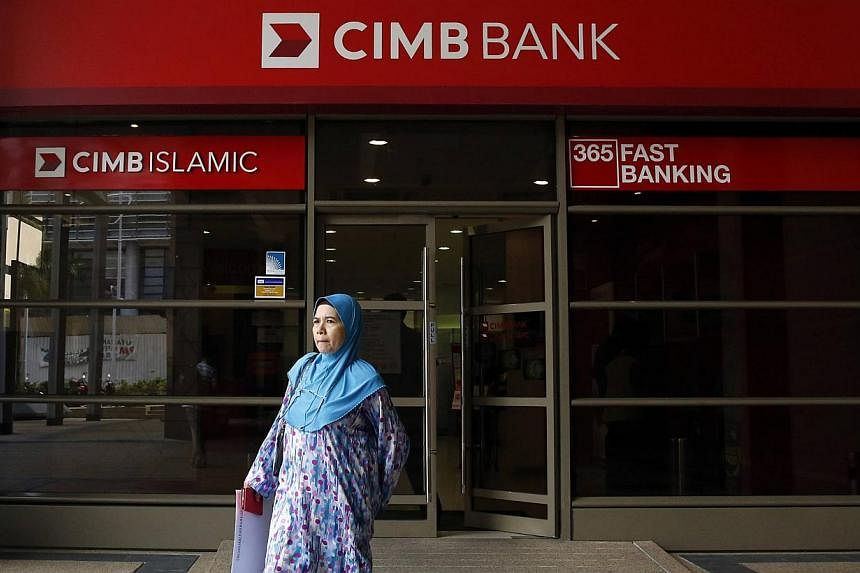 A woman leaves a CIMB bank branch in Putrajaya in this July 17, 2014 file photo. -- PHOTO: REUTERS