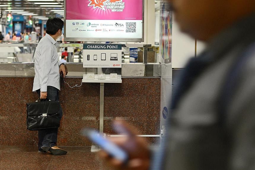 Since the WiFi@MRT trial began in August at City Hall (above), Orchard and Raffles Place stations, daily usage has grown from 100,000 commuters to more than 145,000. All MRT stations will have the service if the trial proves successful. -- PHOTO: ST 