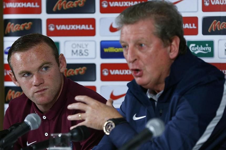 England captain Wayne Rooney (left) listens to manager Roy Hodgson during a news conference at their team hotel in Watford, north of London Oct 8, 2014. Hodgson said Wednesday he had apologised to Rooney regarding his casual comment about the Liverpo