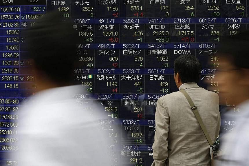 A man looks at an electronic stock quotation board outside a brokerage in Tokyo on Sept 4, 2014. -- PHOTO: REUTERS