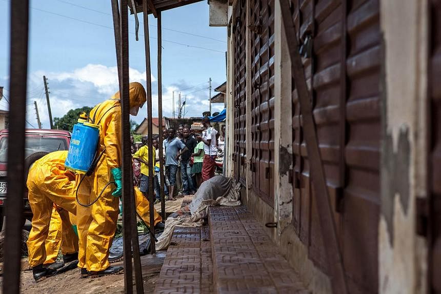 Volunteers look for bodies of people who died of the Ebola virus on Oct 8, 2014, in Freetown, Sierra Leone. -- PHOTO: AFP&nbsp;