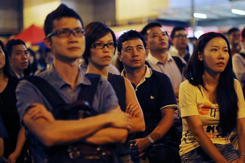 Demonstrators react during a speech after the government cancelled the talks scheduled for Friday as protesters block areas around the government headquarters office in Hong Kong on Oct 9, 2014. -- PHOTO: REUTERS