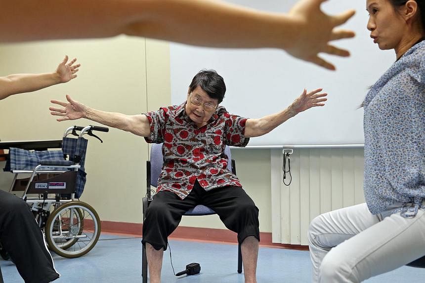 Parkinson's patient Mrs Yeo Jui Hoon, 84, undergoes a new Voice and Movement Group Therapy with (right) Senior Occupational Therapist Tan Xuan Hong at Changi General Hospital. -- ST PHOTO: SEAH KWANG PENG&nbsp;