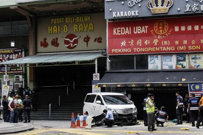 Police work at the scene of a grenade attack outside a shopping centre at Bukit Bintang in Kuala Lumpur on Oct 9, 2014. -- PHOTO: REUTERS