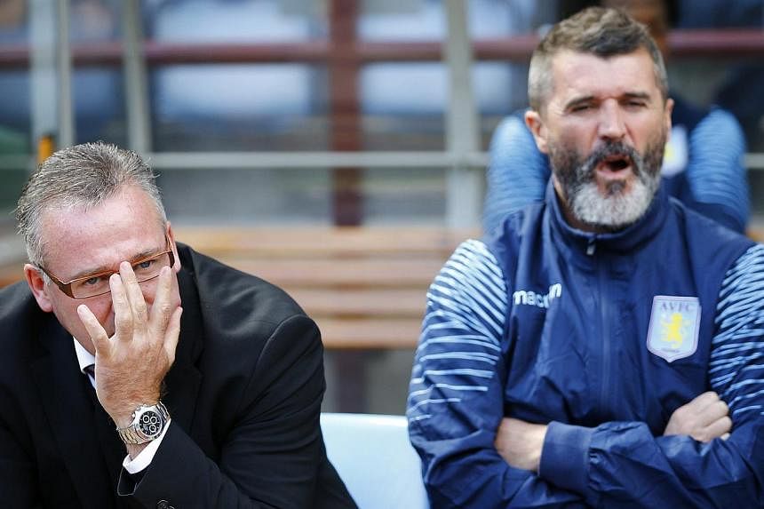 Aston Villa manager Paul Lambert (left) and his assistant Roy Keane sit in the dugout before their English Premier League soccer match against Newcastle United at Villa Park in Birmingham, central England Aug 23, 2014. Keane's war of words with Alex 