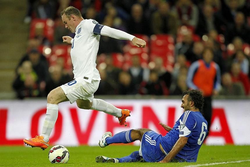 England's forward Wayne Rooney (left) vies for the ball against San Marino's Alessandro Della Valle during a Euro 2016 qualifier football match between England and San Marino at Wembley Stadium in north London, on Oct 9, 2014. -- PHOTO: AFP
