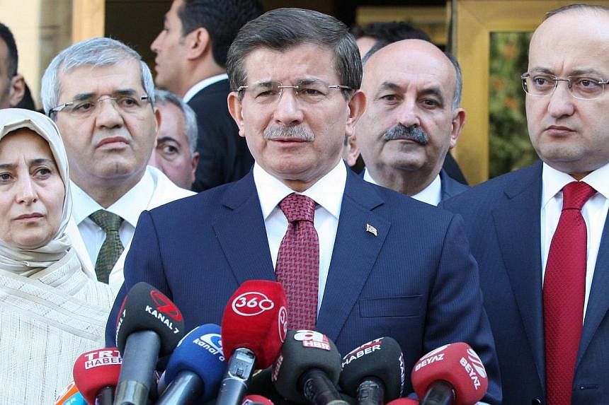 Turkish Prime Minister Ahmet Davutoglu (centre) gives a press conference after visiting the security members injured last night on the sideline of Kurds protests over the government's policy on Islamic State (IS) militants in southeastern Turkey, on 
