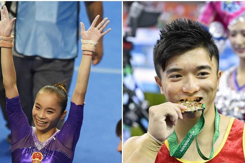 China's Yao Jinnan (left) and Liu Yang celebrate after winning the women's uneven bars final and men's rings final respectively at the gymnastics world championships in Nanning on Oct 11, 2014. -- PHOTO: AFP&nbsp;