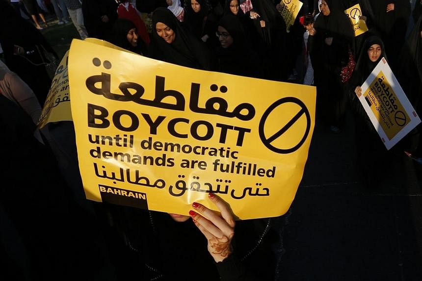 &nbsp;A protester holding a sign marches during a rally organised by Bahrain's main opposition party Al Wefaq in Budaiya, west of Manama, Bahrain on Sept 19, 2014.&nbsp;Bahrain's Shi'ite-led opposition on Saturday announced a boycott of parliamentary