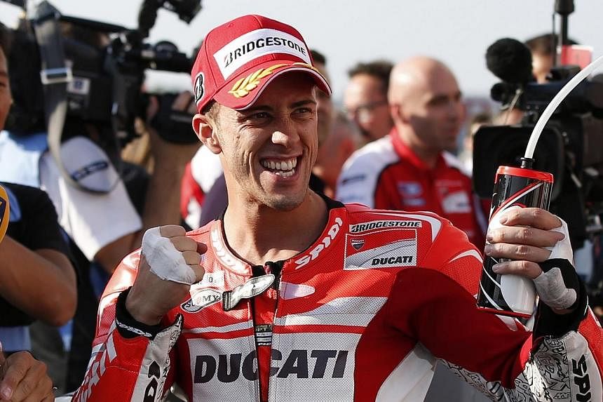 Ducati MotoGP rider Andrea Dovizioso of Italy celebrates after winning the pole position for Sunday's Japanese Grand Prix during a qualifying session at the Twin Ring Motegi circuit in Motegi, north of Tokyo on Oct 11, 2014. -- PHOTO: REUTERS