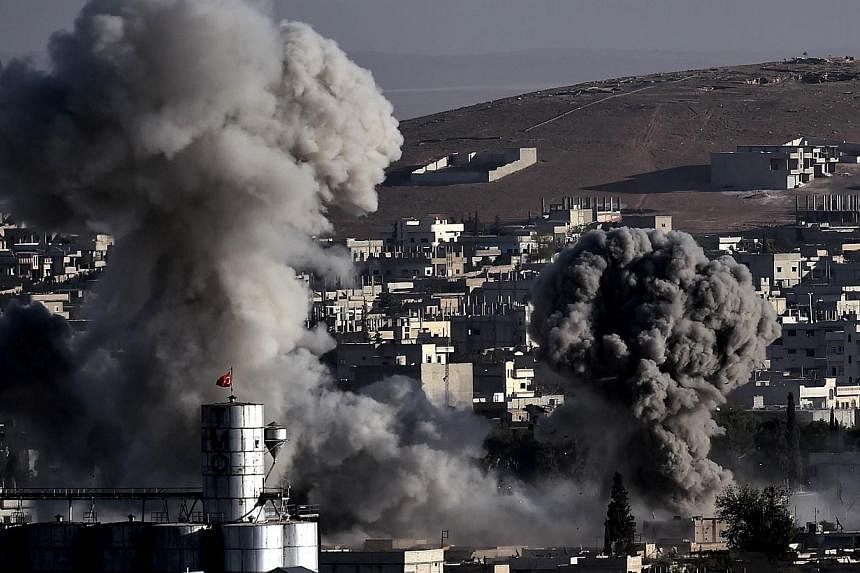 Smoke rises after strikes from the US-led coalition in the Syrian town of Ain al-Arab, known as Kobane by the Kurds, in the south-eastern village of Mursitpinar, Sanliurfa province, on Oct 10, 2014. -- PHOTO: AFP