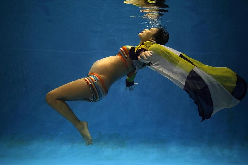 Ms Jiejin Qiu, who is six months pregnant with her first baby, posing underwater during a photo shoot at a wedding photo studio in Shanghai. Under China’s one-child policy, Ms Qiu and others like her are allowed to have only one baby. Couples viola