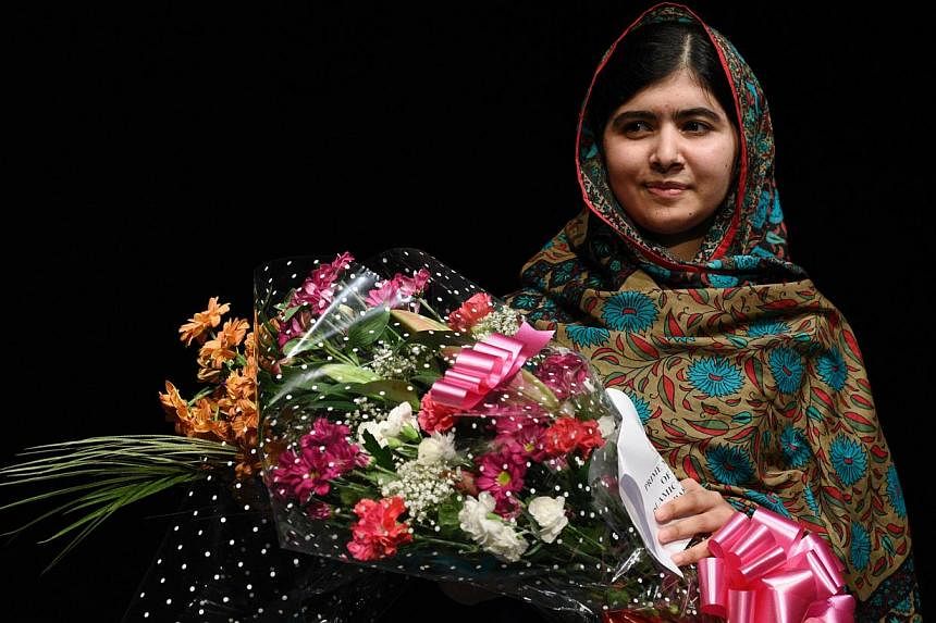 Pakistani rights activist Malala Yousafzai holds a bouquet of flowers after addressing the media in Birmingham, central England on Oct 10, 2014.&nbsp;Malala will travel to Canada to become an honorary citizen, Prime Minister Stephen Harper said Frida
