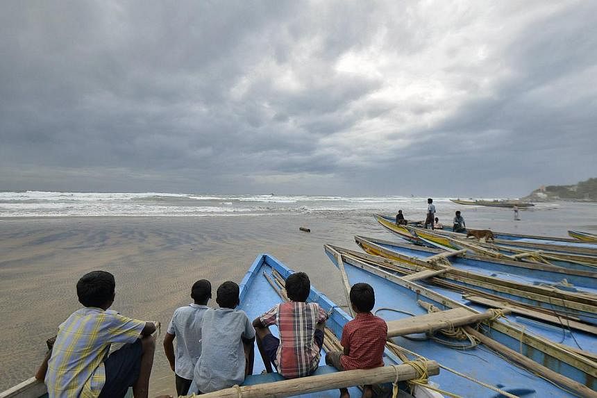Children sit on fishing boats by the shore before being evacuated, at Visakhapatnam district in the southern Indian state of Andhra Pradesh on Oct 11, 2014. -- PHOTO: REUTERS