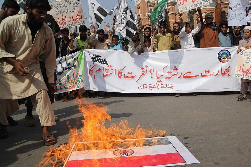 A Pakistani activist of the Islamic hardline organisation Jamaat ud Dawa (JuD) torches an Indian flag during a demonstration in Multan on Oct 10, 2014.&nbsp;At least seven people were killed and 42 hurt in a stampede during an anti-government protest