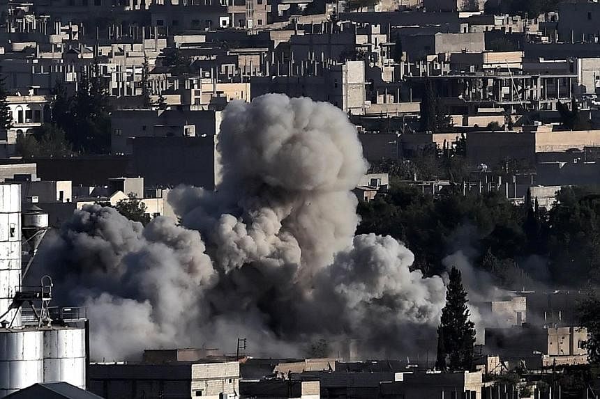 Smoke rises after strikes from the US-led coalition in the Syrian town of Ain al-Arab, known as Kobane by the Kurds, in the south-eastern village of Mursitpinar, Sanliurfa province, on Oct 10, 2014. -- PHOTO: AFP