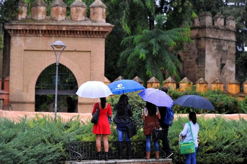 Tourists try to peer over a fence at Los Jardines de Murillo that is to be one of the sets for the fifth season of the series Game Of Thrones at the Reales Alcazares (Royal Palace) in Sevilla on Oct 10, 2014. Film crews began shooting part of the fif
