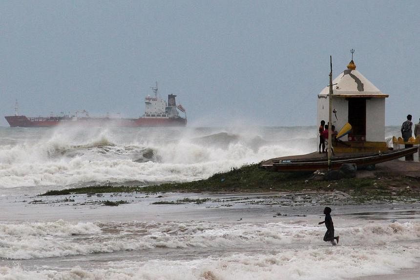 An Indian youth is pictured in the surf as large waves hit the beach ahead of Cyclone Hudhud making expected landfall in Visakhapatnam on Oct 11, 2014.&nbsp;India placed its navy on high alert and evacuated around 350,000 people from eastern coastal 