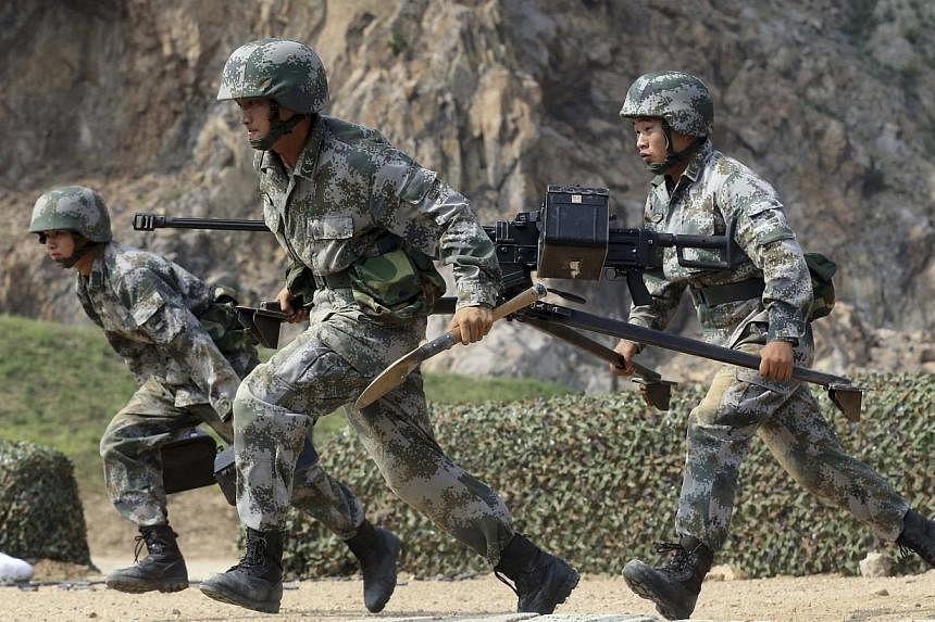 Members of the People's Liberation Army (PLA) coastal defence force carry a machine gun during a drill to mark the upcoming 87th Army Day at a military base in Qingdao, Shandong province on July 29, 2014.&nbsp;Weaknesses in China's military training 