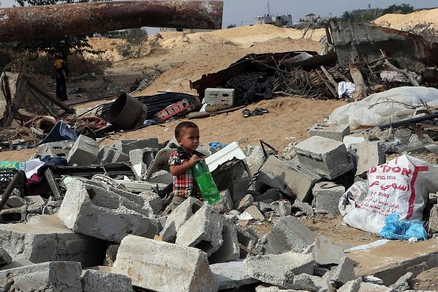 A Palestinian child walks admist the rubble of his home in the southern Gaza Strip town of Rafah on Oct 12, 2014. Qatar said on Sunday, Oct 12, that it would provide US$1 billion (S$1.28 billion) in reconstruction assistance for Gaza following a war 