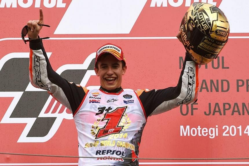Repsol Honda Team rider Marc Marquez of Spain celebrates his win of the 2014 MotoGP World Championship after finishing in second place at the MotoGP Japanese Grand Prix in Motegi, Tochigi prefecture on Oct 12, 2014. -- PHOTO: AFP