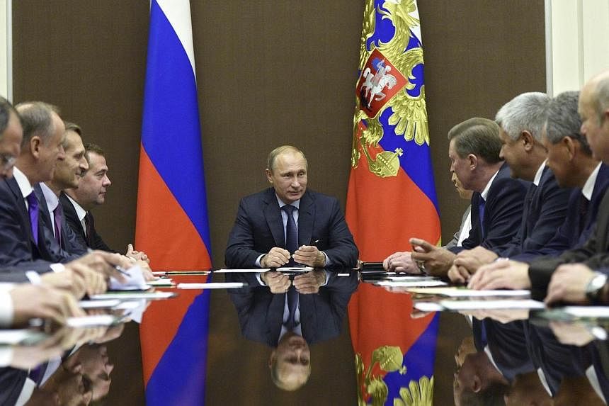 Russia's President Vladimir Putin (centre) chairs a meeting of the Security Council at the Bocharov Ruchei state residence in Sochi, on Oct 11, 2014.&nbsp;Mr Putin has ordered Russian troops to withdraw to their permanent bases after military exercis