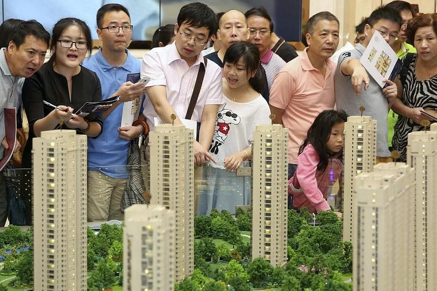 Customers look at a model of a new residential compound at a showroom in Hangzhou, Zhejiang province in this Aug 17, 2014 file picture.&nbsp;The chance of a hard landing for China's economy is very small in spite of worries about the country's real-e