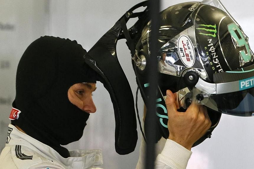 Mercedes Formula One driver Nico Rosberg of Germany puts on a helmet displaying a sticker in support of Marussia Formula One driver Jules Bianchi during the third free practice session at the Russian F1 Grand Prix in the Sochi Autodrom circuit Oct 11