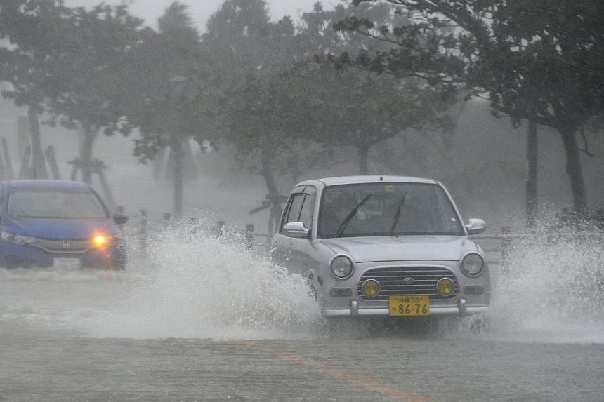 Cars drive on a waterlogged road due to heavy rain caused by approaching Typhoon Vongfong in Nishihara town on Japan's southern island of Okinawa, in this photo taken by Kyodo on Oct 11, 2014. -- PHOTO: REUTERS