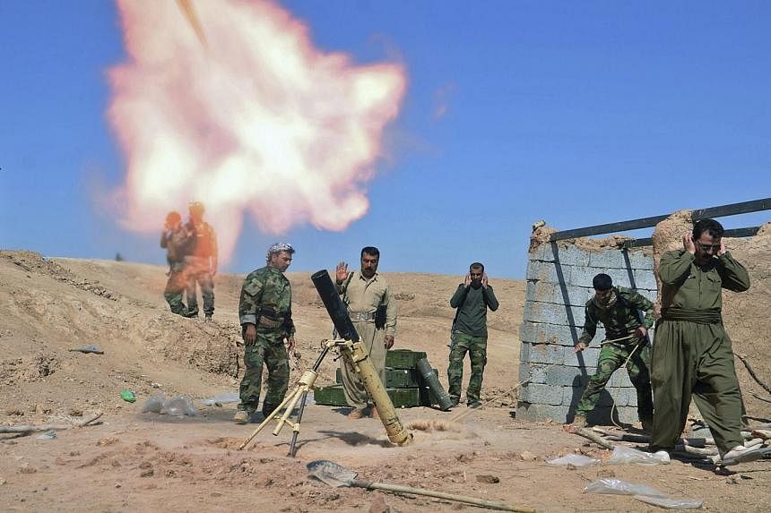 Kurdish fighters fire a mortar during clashes with Islamic State militants in the al-Zerga area near Tikrit city, in Salahuddin province on Oct 8, 2014. -- PHOTO: REUTERS