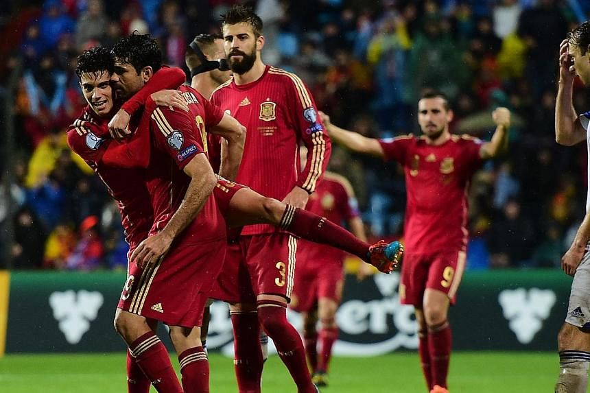 Spain's Diego Costa (second from left) celebrates with teammates after scoring during the Group C Euro 2016 qualifying football match between Luxembourg and Spain at the Josy Barthel stadium in Luxembourg , on Oct 12, 2014. -- PHOTO: AFP