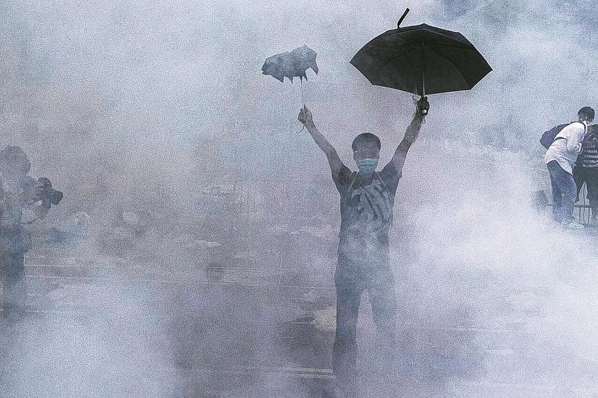 A pro-democracy demonstrator gestures after police fired tear gas towards protesters near the Hong Kong government headquarters on Sept 28, 2014.&nbsp;Denying his involvement in a tear gas attack last month on protestors calling for free elections in