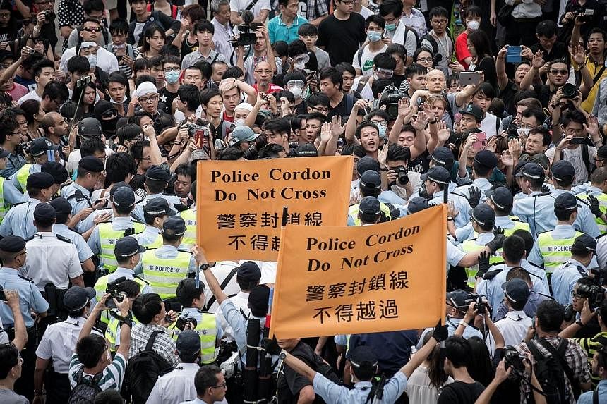 Policemen cordon an area where pro-democracy demonstrators confronted anti-occupy protesters (not in picture) in the Admiralty district of Hong Kong on Oct 13, 2014.&nbsp;With pro-government and pro-democracy protestors now going head to head in Hong