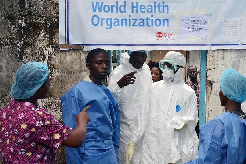 Health workers in protective gear pose at the entrance of the Ebola treatment unit of the John F. Kennedy Medical Center, in the Liberian capital Monrovia, on Oct 13, 2014.&nbsp;Many Liberian healthcare workers on the frontline of the battle against 