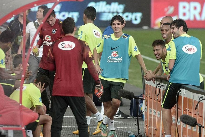 Brazil's players chat after their football training session at the new National stadium in Singapore on Oct 13, 2014. -- PHOTO: AFP