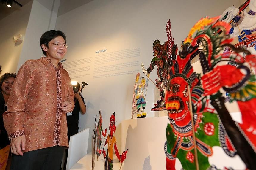 Minister Lawrence Wong looking at a display of fusion wanyang kulit that will be used in a shadow-play performance using the storyline and characters from Star Wars. A three-week long festival showcase at the Malay Heritage Centre for traditional and