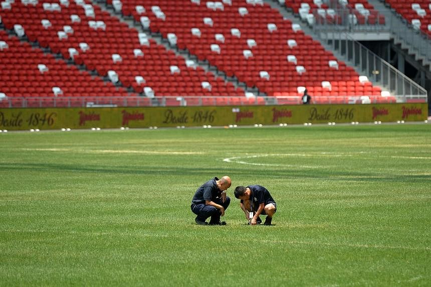Groundsmen checking the pitch at the Sports Hub. -- ST PHOTO:&nbsp;JAMIE KOH
