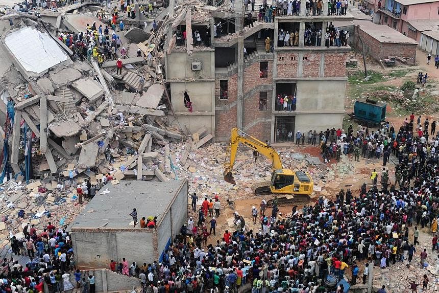 In this photograph taken on April 25, 2013, Bangladeshi volunteers and rescue workers are pictured at the scene after an eight-storey building collapsed in Savar on the outskirts of Dhaka. -- PHOTO: AFP