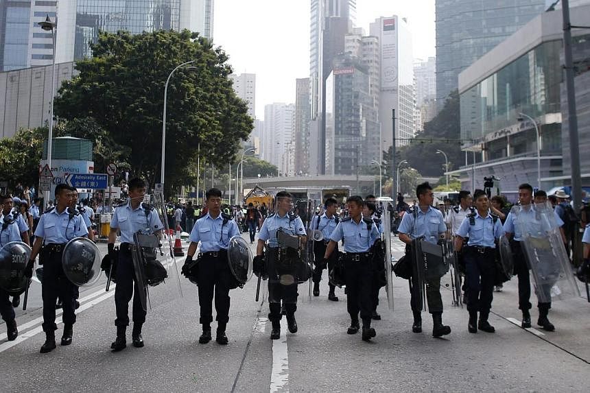 Police officers take control of Queensway Road as they remove barricades from a protest site in Admiralty near the government headquarters in Hong Kong on Oct 14, 2014. -- PHOTO: REUTERS&nbsp;