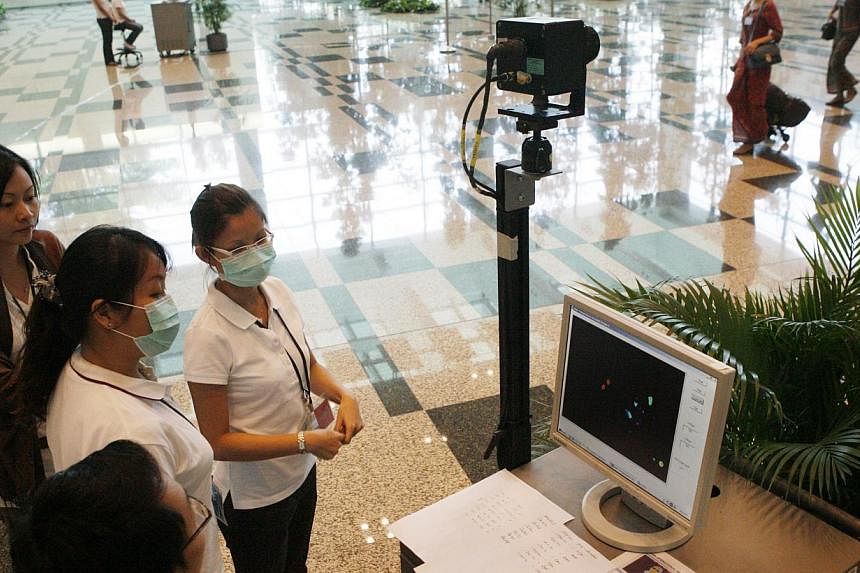 &nbsp;Health screening officers at Changi Airport.&nbsp;New measures to screen travellers for Ebola will be introduced at Changi Airport from noon tomorrow. -- PHOTO: ZAOBAO FILE