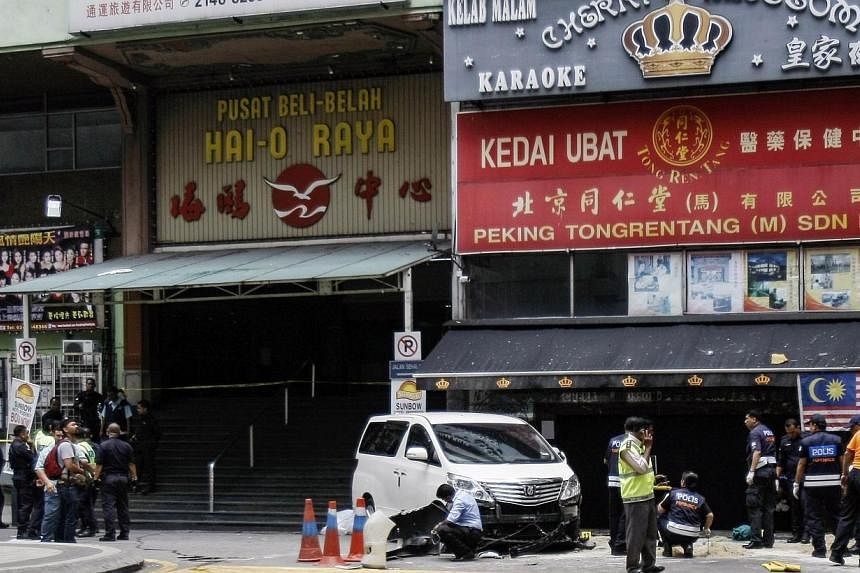 Police work at the scene of a grenade attack outside a shopping centre at Bukit Bintang in Kuala Lumpur on Oct 9, 2014.&nbsp;A gambling kingpin believed to be the target of assassination outside a karaoke lounge in Malaysia which killed a man gave hi