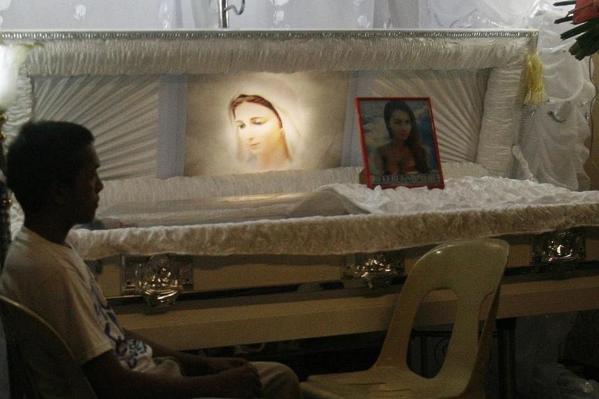 A relative grieves next to the coffin containing the body of a 26-year-old transgender Filipino, who was found strangled in a hotel room, during a wake in Olongapo city north of Manila on Oct 13, 2014. -- PHOTO: REUTERS