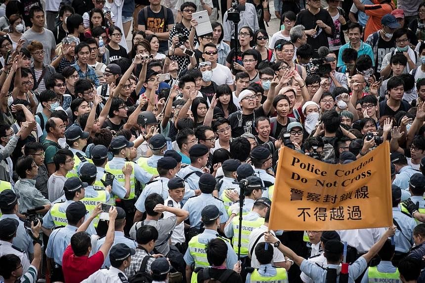 Policemen cordon an area where pro-democracy demonstrators confronted anti-occupy protesters (not in picture) in the Admiralty district of Hong Kong on Oct 13, 2014.&nbsp;Attacks by masked men on Hong Kong's pro-democracy protesters have shone an unc