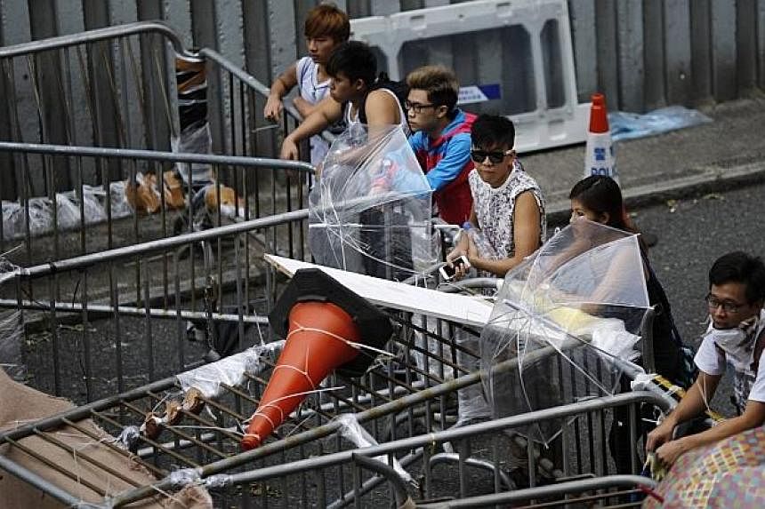 Pro-democracy protesters stand by a barricade near the government headquarters building in Hong Kong on Oct 14, 2014. -- PHOTO: REUTERS