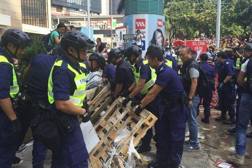 Police armed with bolt cutters, chainsaws and sledgehammers made a renewed attempt on Tuesday to remove barricades along a stretch of the main protest site held by pro-democracy demonstrators for the past fortnight. -- ST PHOTO: LI XUEYING
